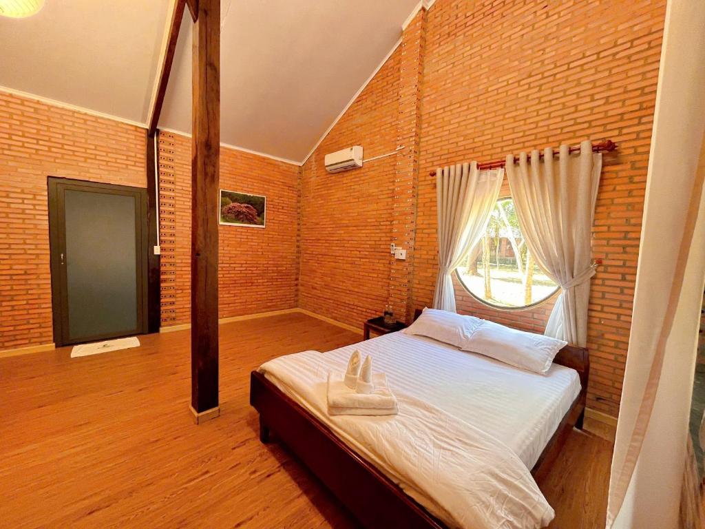 a bedroom with a bed and a brick wall at An Tiên Ecolodge in Tân Phú