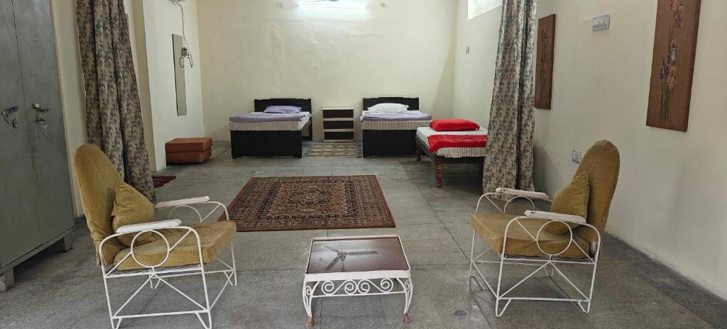 a room with three beds and two chairs and a table at Dalpat singh in Jaipur