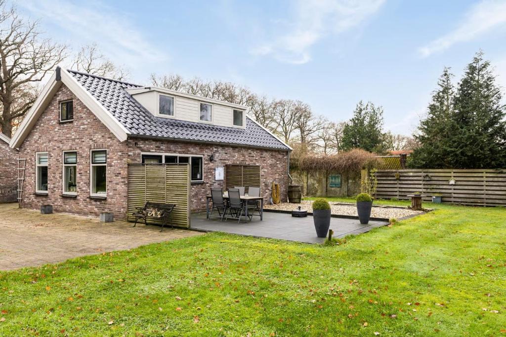 a brick house with a patio in the yard at 't Skoallehus in Steggerda
