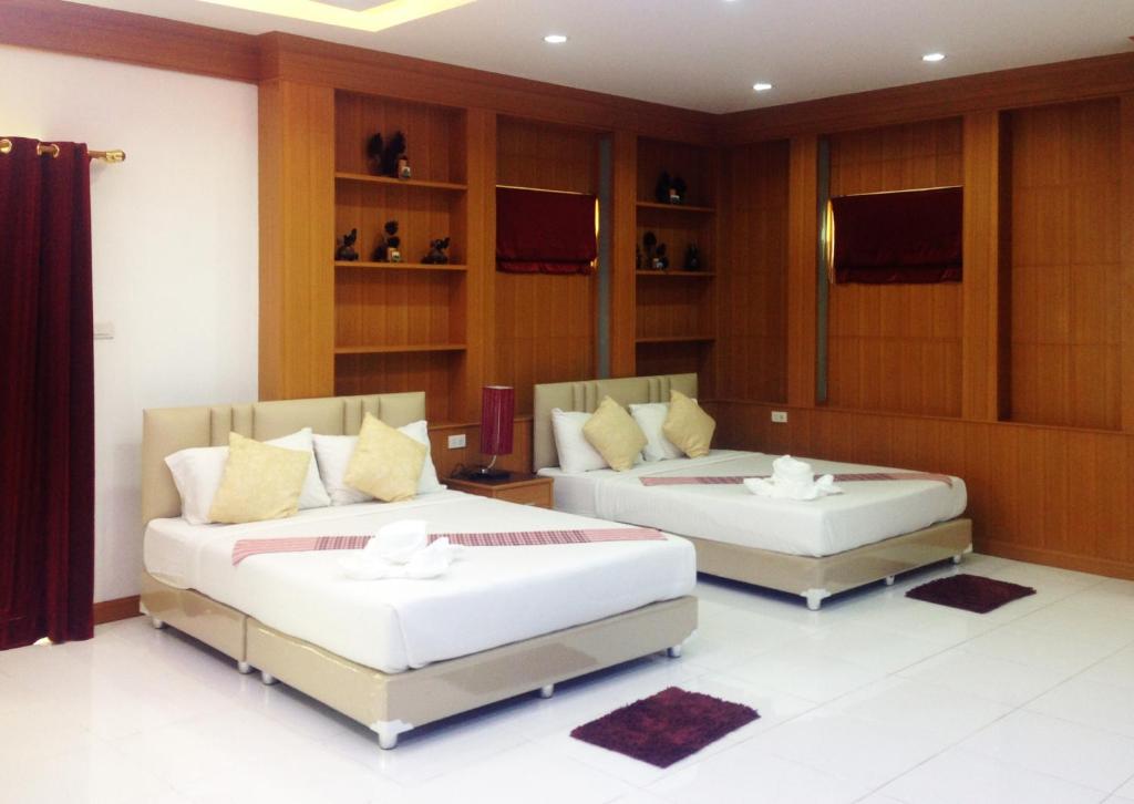 a bedroom with two beds and a tv at Parada Place in Khon Kaen