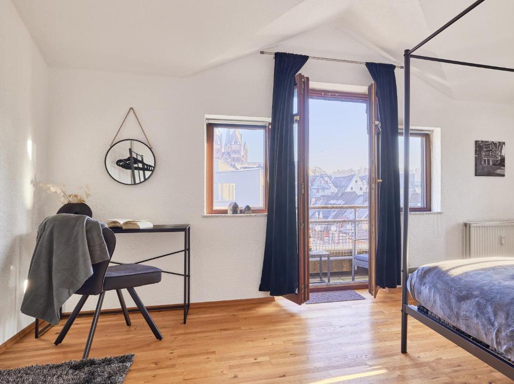 a bedroom with a bed and a desk and a window at Traumferienwohnung Domblick - Parkplatz inklusive, zentral mit Altstadtblick & Netflix in Limburg an der Lahn