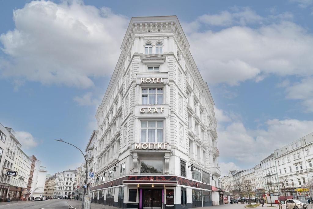 a white building with a sign on the side of it at Garner Hotel Hamburg - Graf Moltke by IHG in Hamburg