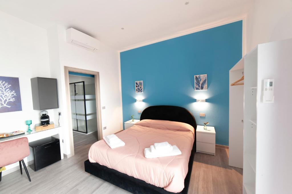 a bedroom with a pink bed and a blue wall at Mhometredici Guest House - Camere moderne a Sestu vicino aeroporto Cagliari e Policlinico in Sestu