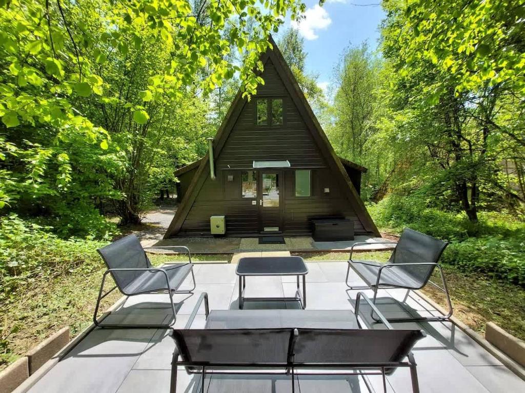 a group of chairs and a table in front of a cabin at Chalet Het Hulstje 2 in Durbuy
