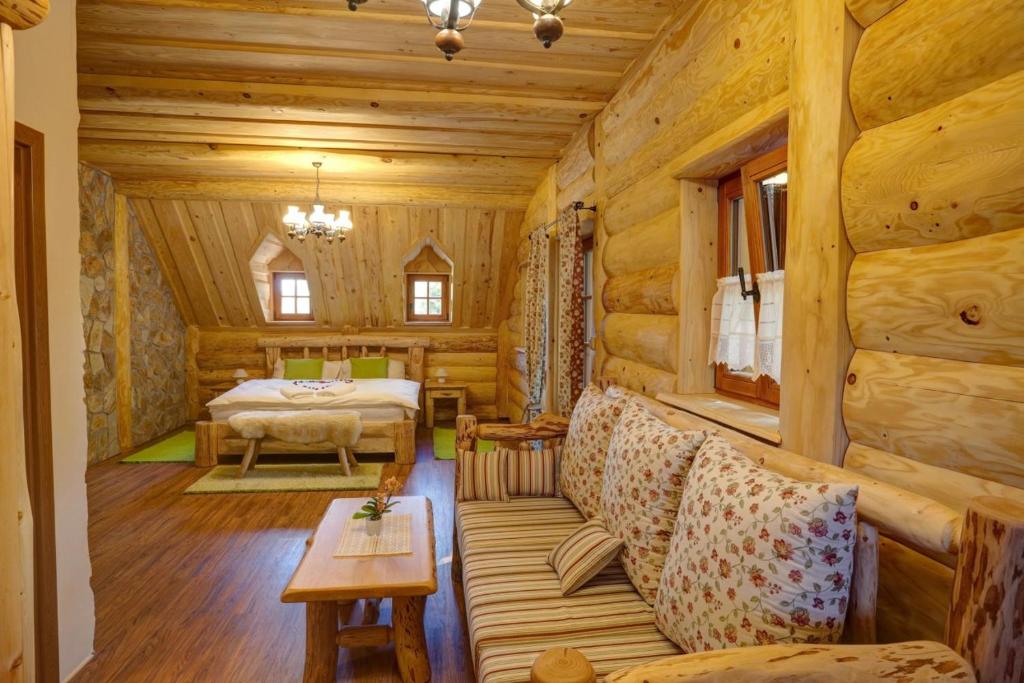 a log cabin room with a bed and a couch at Srub u Medvěda in Nový Jičín