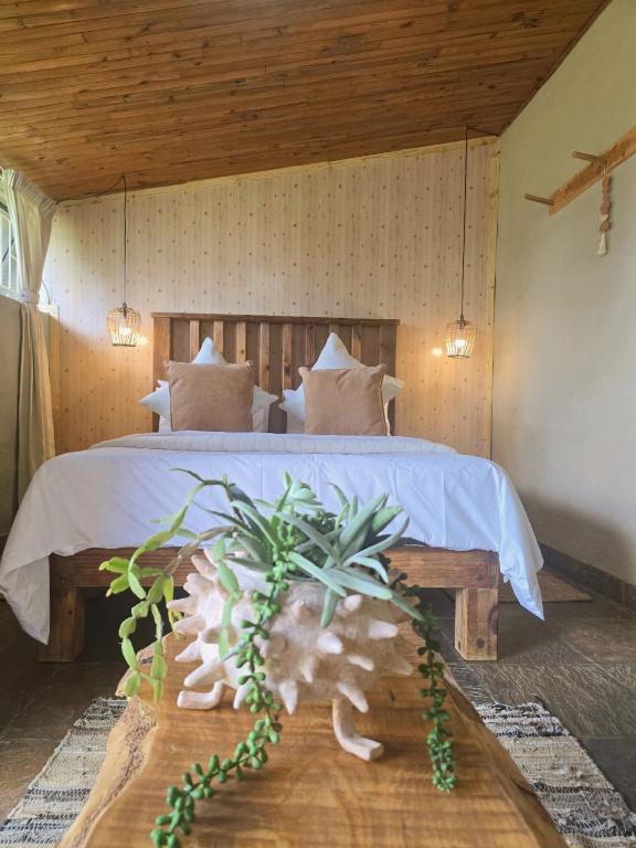 a bedroom with a large bed with a wooden ceiling at Rustique in Graskop