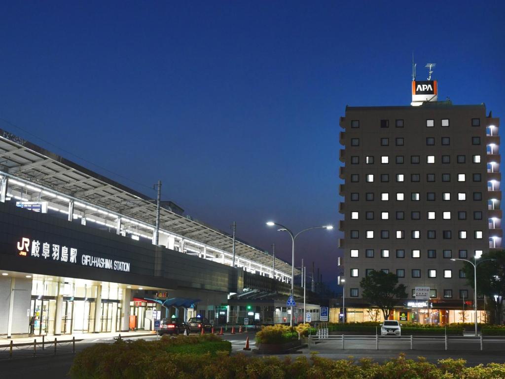 a building with a train on top of it at night at APA Hotel Gifu Hashima Ekimae in Hashima