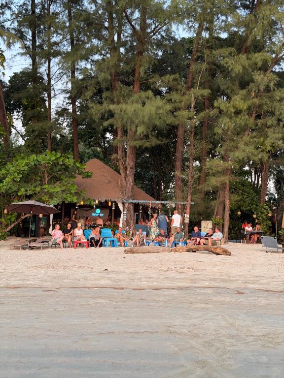 a group of people sitting on the beach at Relaxbar&bungalow in Ko Phayam