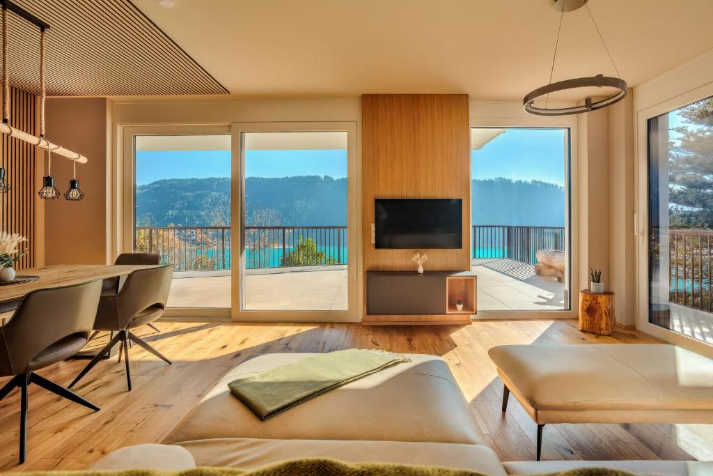 a living room with a dining table and a television at Adlerblick Deluxe Seeblick Ossiacher See in Annenheim
