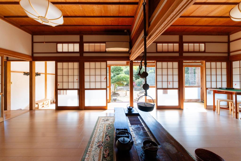 a living room with wooden ceilings and windows and a table at Wakamizu Minpaku in Tōgane