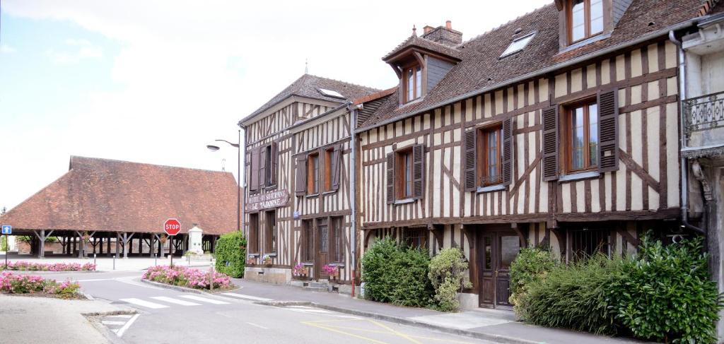 un viejo edificio en una calle con una señal de stop en Logis Le Tadorne, en Piney