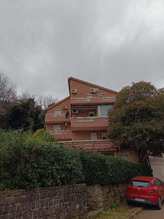 a red car parked in front of a building at Una Apartments in Budva
