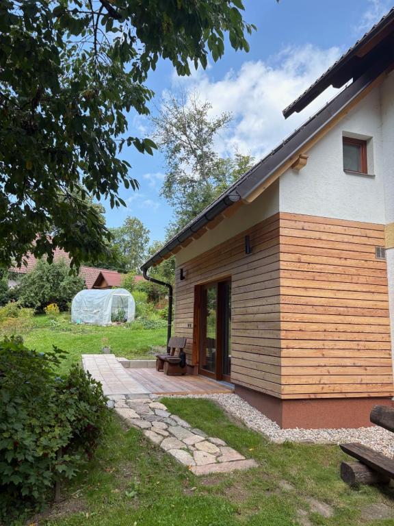a house with a wooden porch with a bench outside at Selina in Janske Lazne