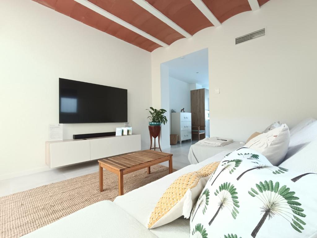 a white living room with a flat screen tv at La Llar de la Font in Barraca de Aguas Vivas