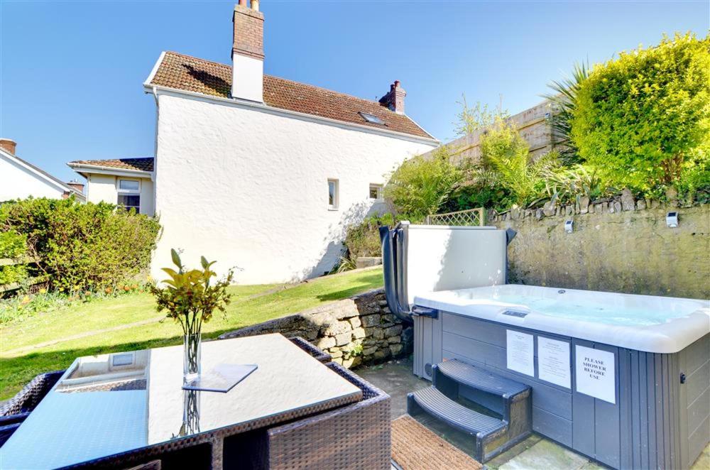 a backyard with a hot tub and a table at 3 Bed in Croyde oc-yellow in Croyde