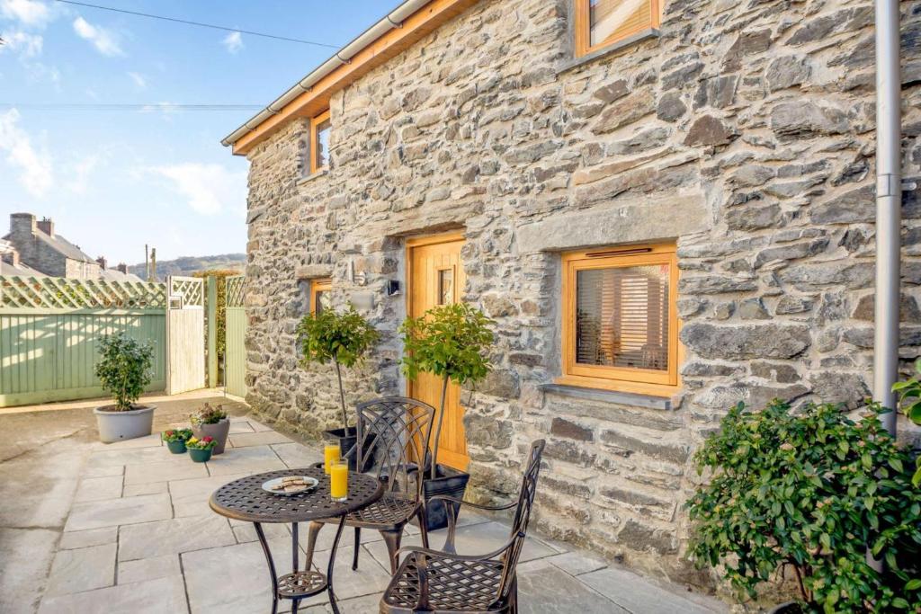 a patio with a table and chairs in front of a stone building at 1 Bed in Bala oc-b27365 in Bala