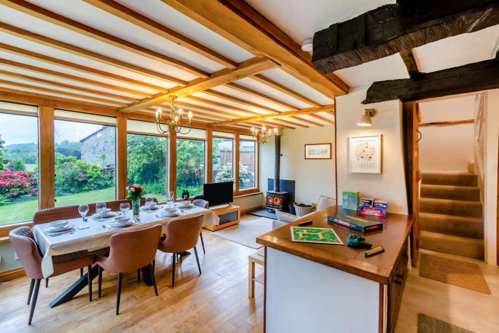 a dining room with a table and chairs and windows at 4 Bed in Satterthwaite oc-c32334 in Grizedale