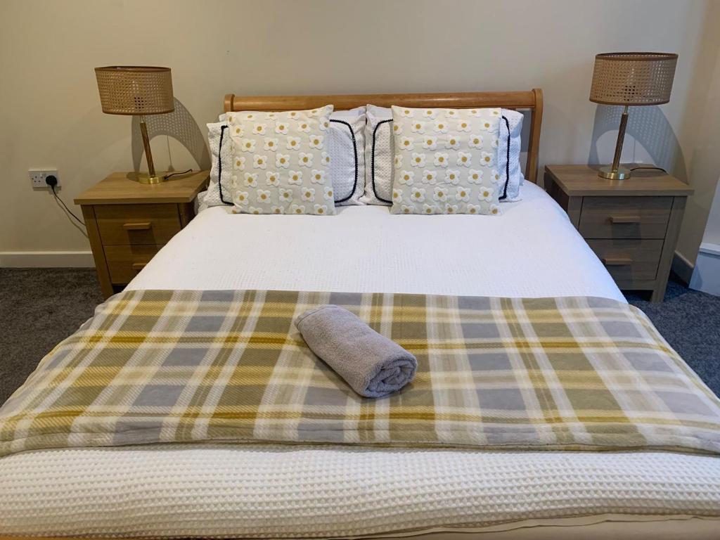 a bed with a plaid blanket and two night stands at 36 flat 1 - Room 1 in Swansea