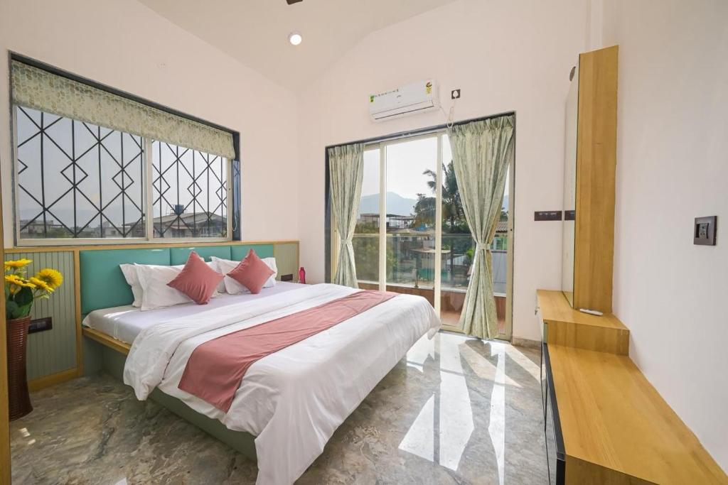 a bedroom with a large bed and a large window at Vrundavan Villa Lonavala in Malavli