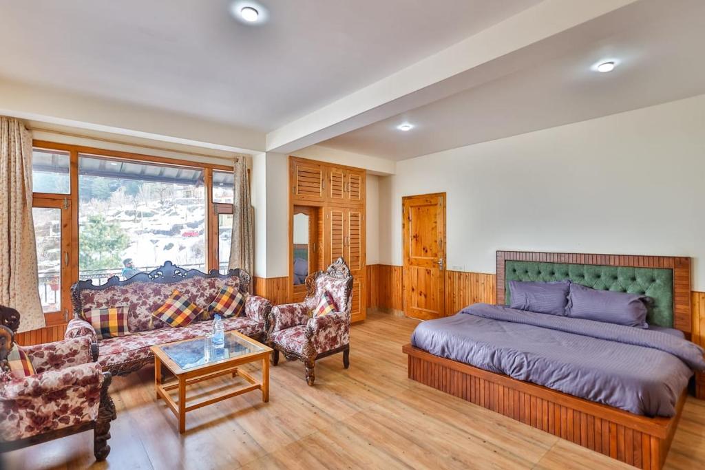 a bedroom with a bed and a couch and a table at Manali Parvat View in Jagatsukh