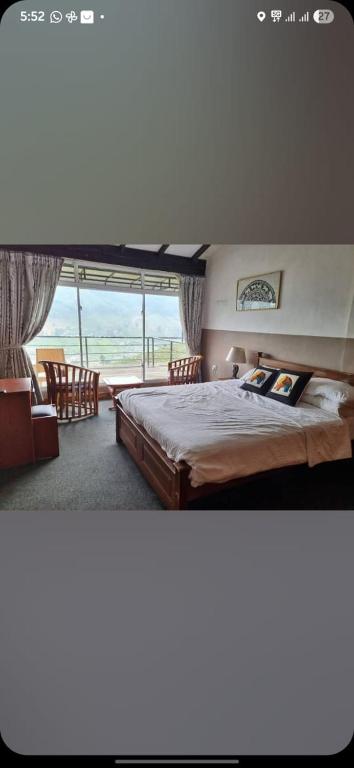 a bedroom with a bed and a large window at Mount view cottage in Nuwara Eliya