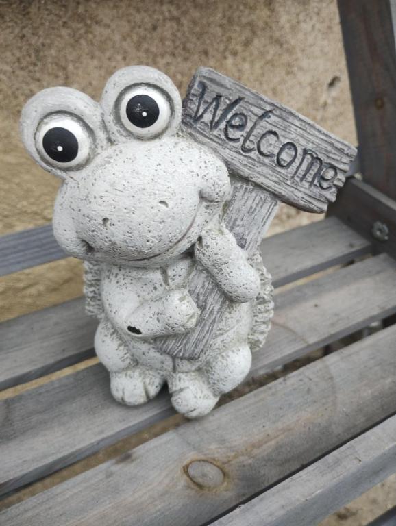 a figurine of a frog holding a welcome sign at En passant par La Maraude in Vigneulles-lès-Hattonchâtel