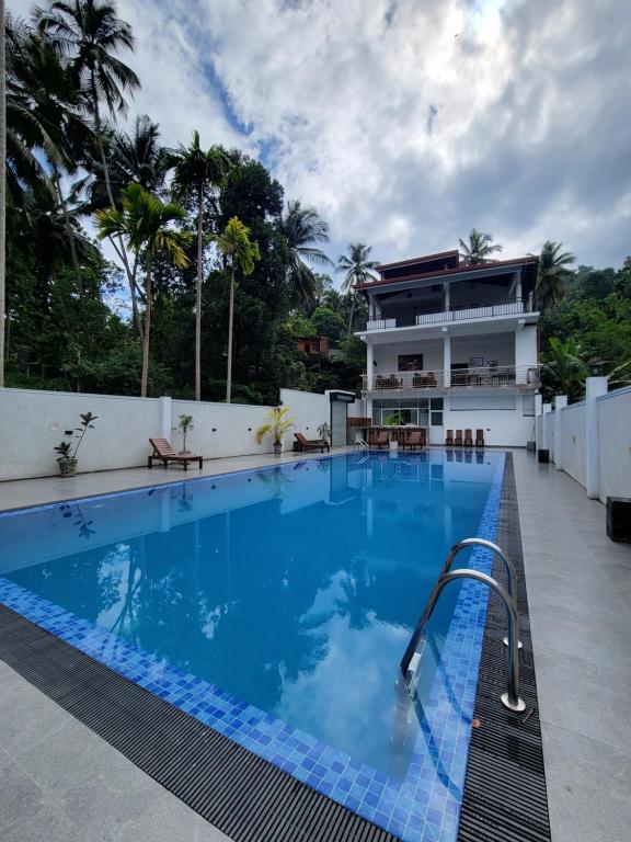 a large swimming pool next to a building at The Secret Place Hotel & Resort in Kandy