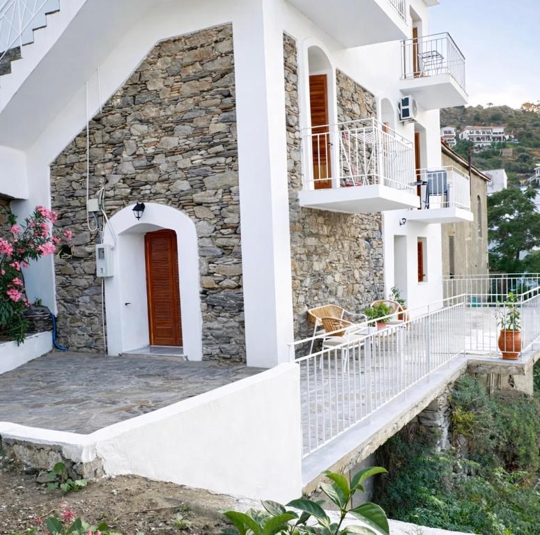 a house with white walls and a staircase at The Icarian resort " Dourediko" by BRP-PROPERTIES in Evdilos