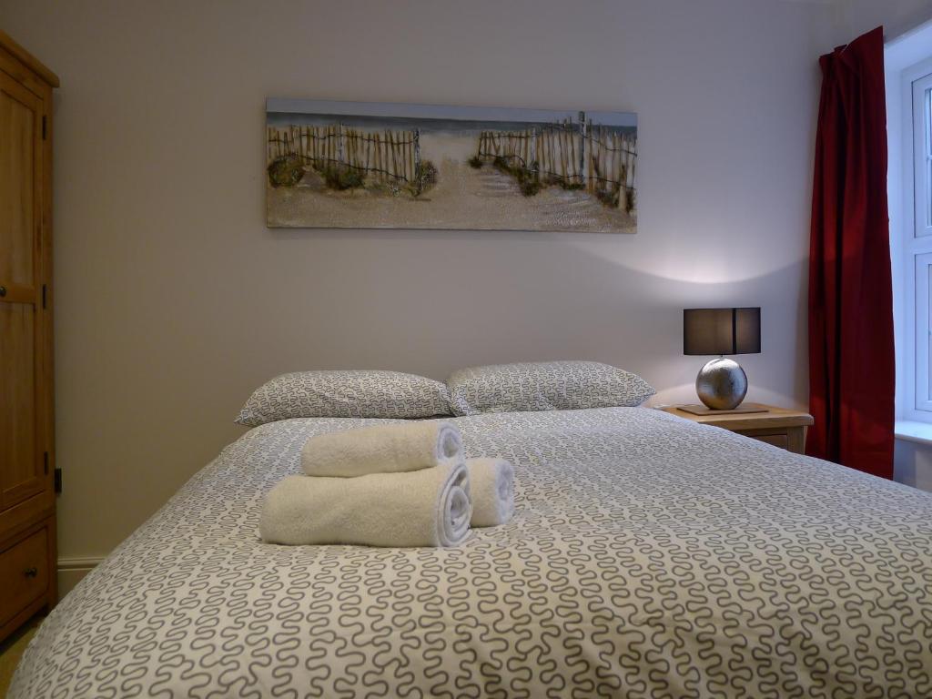 um quarto com uma cama com duas toalhas em Church Court Apartments em Rugby