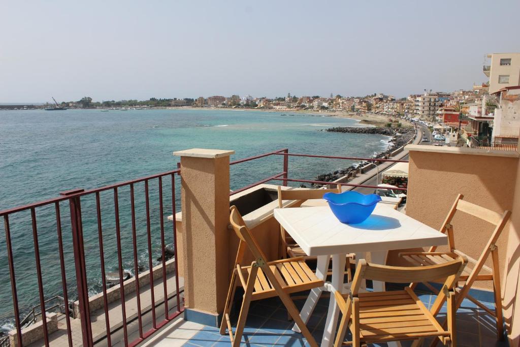 balcón con mesa, sillas y vistas al océano en Casa vancanze Vista d'incanto, en Giardini Naxos