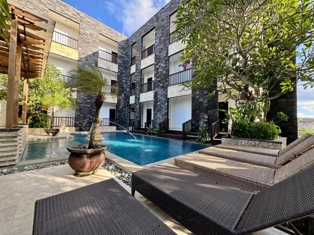 a courtyard with a swimming pool in a building at Mamo Hotel Uluwatu in Uluwatu