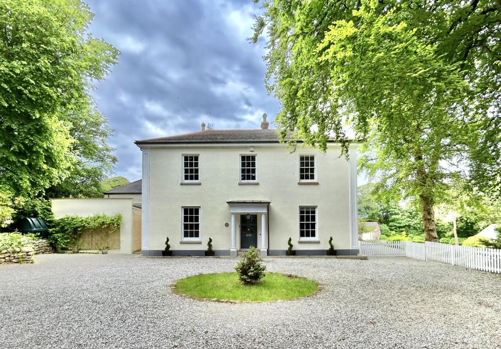 a large white house with a gravel driveway at Sancreed House B&B in Penzance