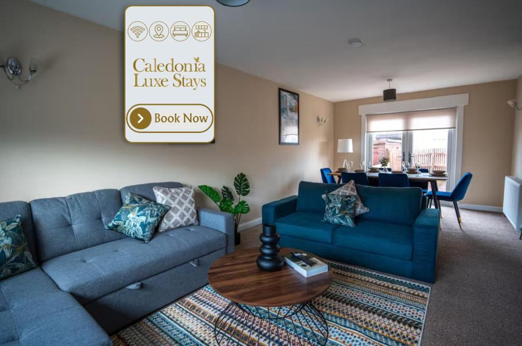 a living room with blue couches and a table at Skye House in Grangemouth