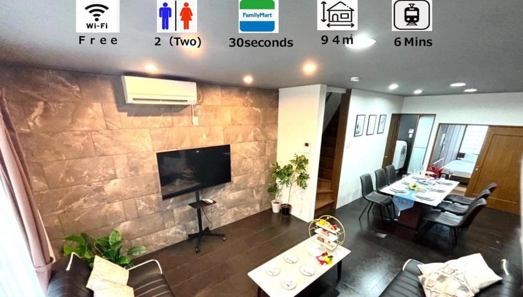 a living room with a stone wall with a tv at HOTTOSTAY OoGANE in Nagoya