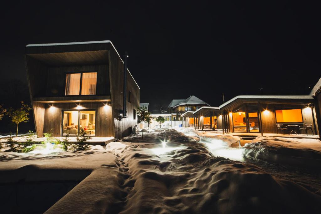 a house in the snow at night with lights at La Villa Chalet and Spa in Polyana