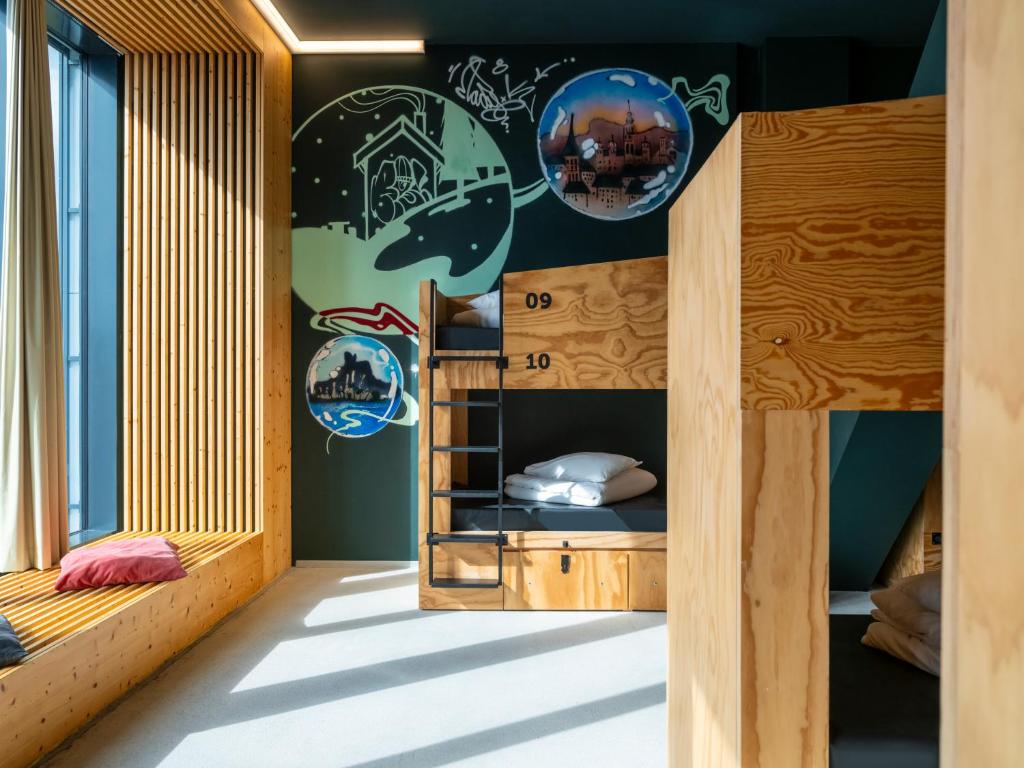 a room with bunk beds and a wall with stickers at JO&JOE Vienna in Vienna