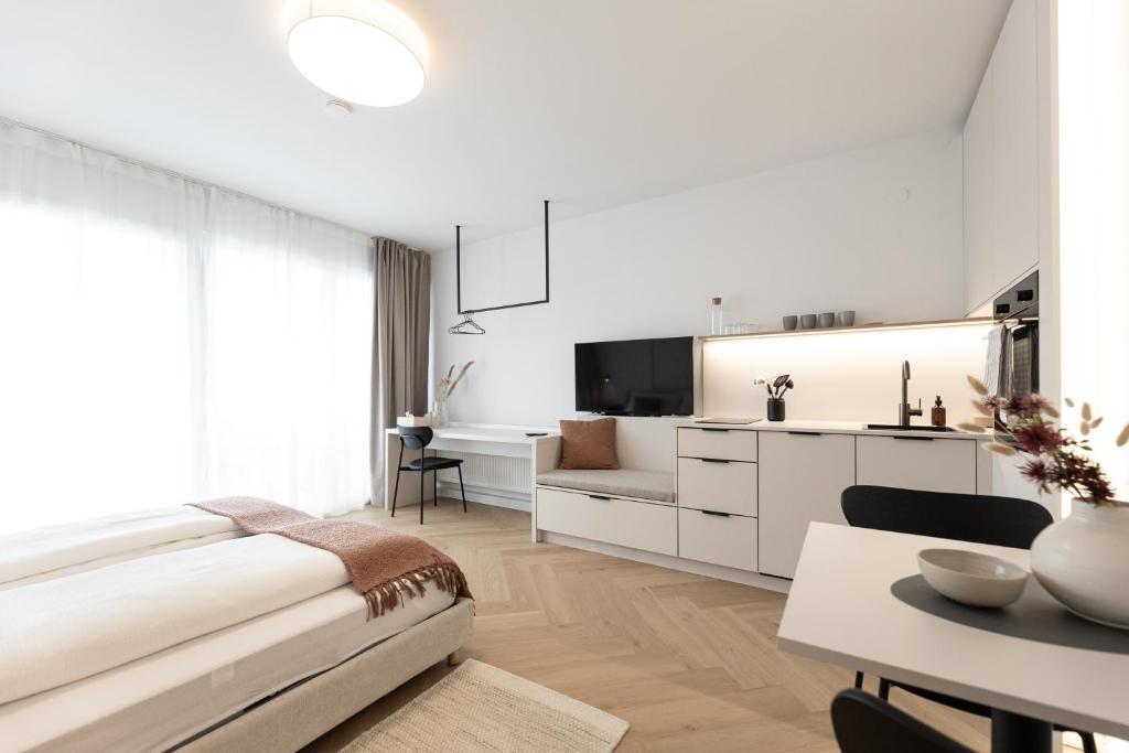 a white living room with a couch and a table at Studio 4 in Bad Schallerbach