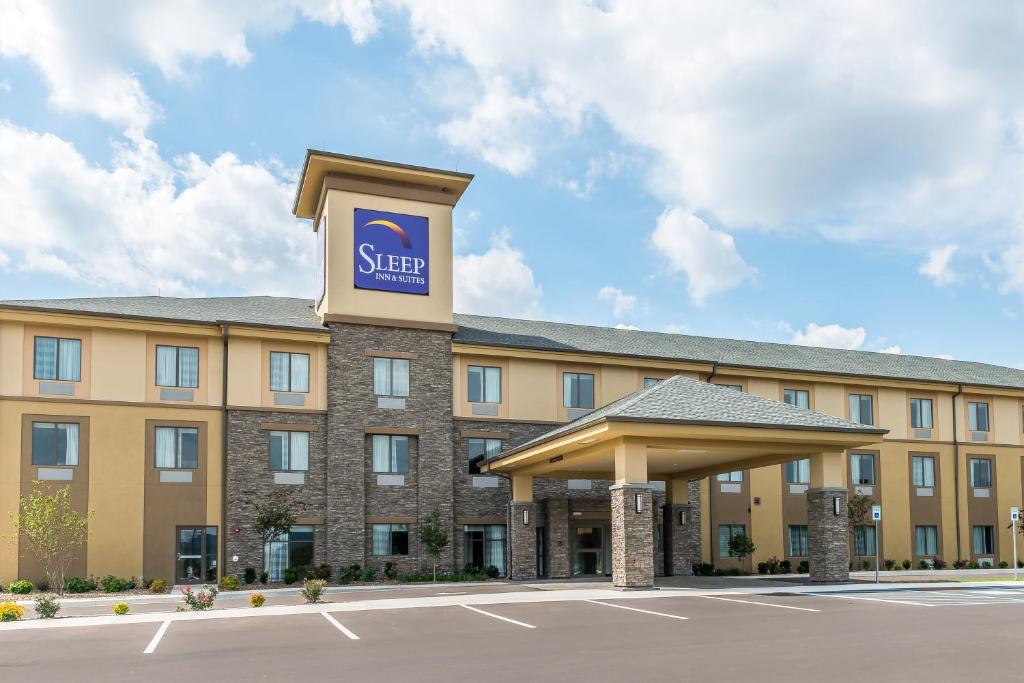 a hotel with a sign on the front of a building at Sleep Inn & Suites Cumberland in Cumberland