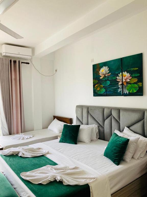 a bedroom with two beds with green and white at Emerald Mountain Resort in Ampitiya