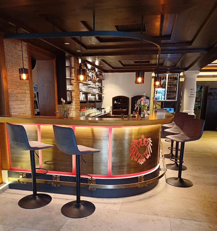 a bar in a restaurant with three chairs around it at B&B Kaiserstube in Flachau