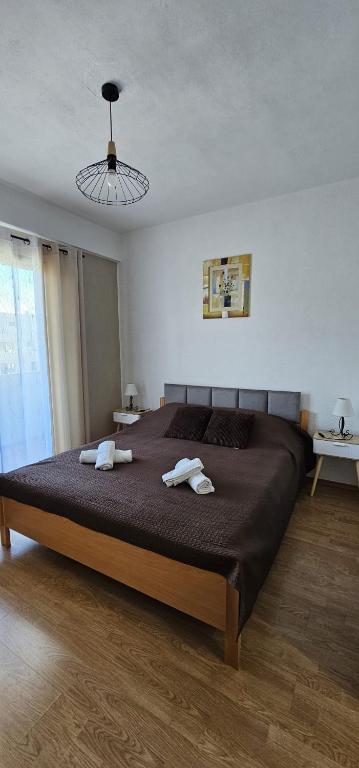 a bedroom with a large bed with two towels on it at Apartments Sime in Sukošan