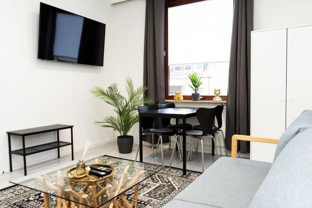 a living room with a table and a couch at Apartment Central - Free parking - 5 people - 3 rooms - 3 TVs - boxspring - wifi in Bremen