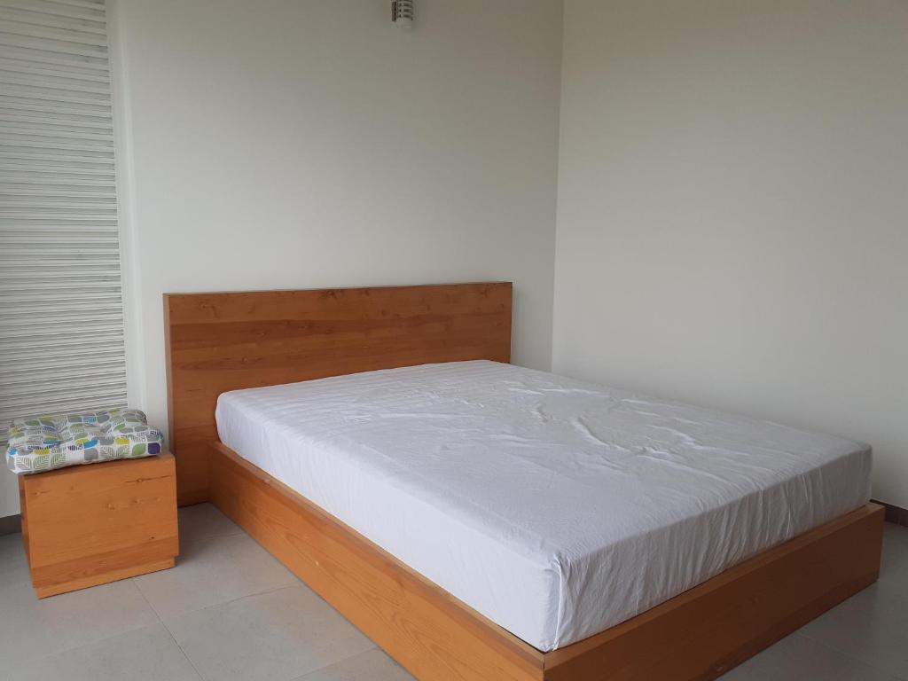 a bed in a bedroom with a wooden bed frame at Sathmani One in Nikawatawana