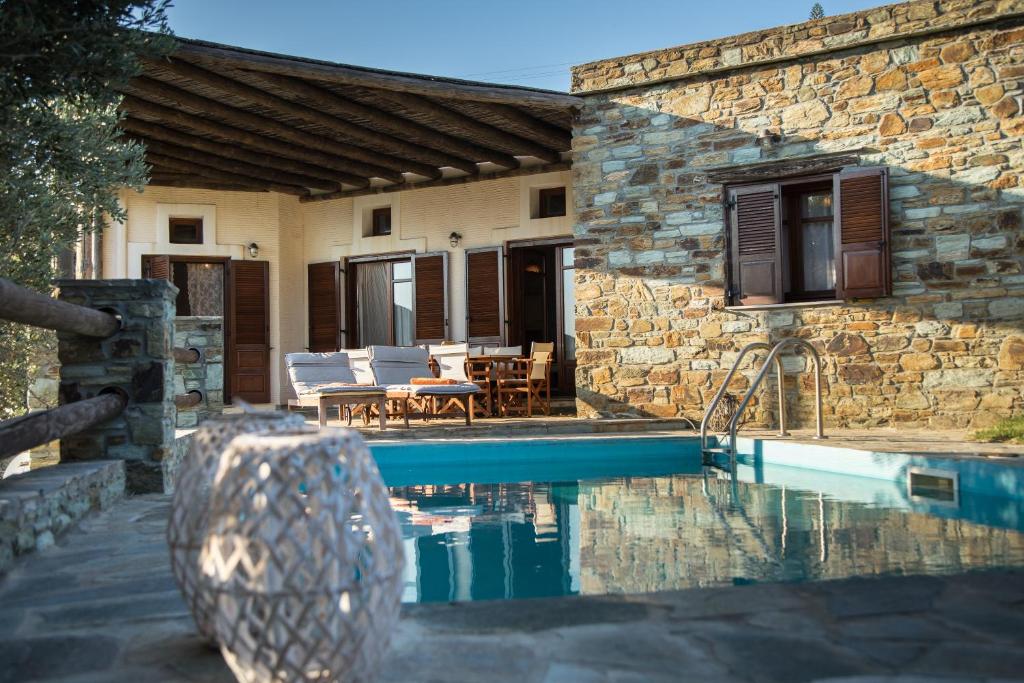 a house with a swimming pool in front of a house at Villa Sophia in Andros