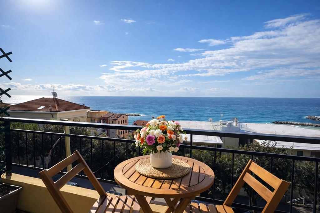 a table with a vase of flowers on a balcony at La Casa Di Gianni - Vista Mare in Ospedaletti