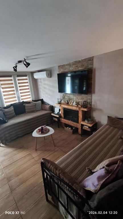 a living room with a couch and a flat screen tv at Zoe garden home in Spata