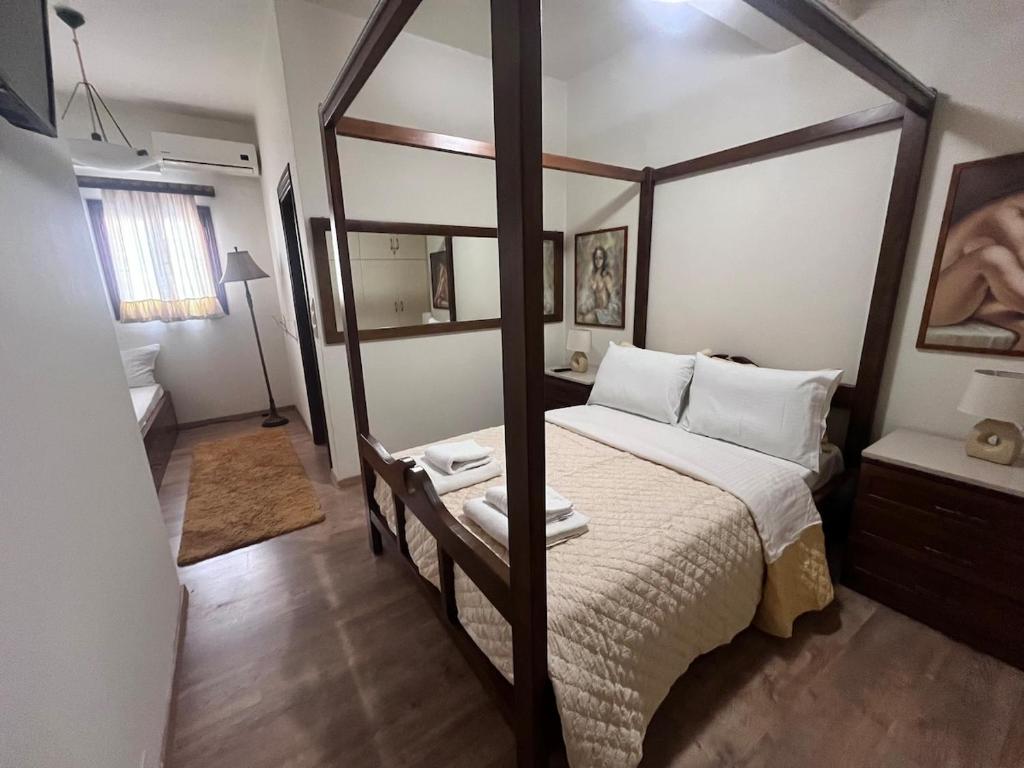 a bedroom with a four poster bed with white pillows at Stone house Anogeia in Anogeia