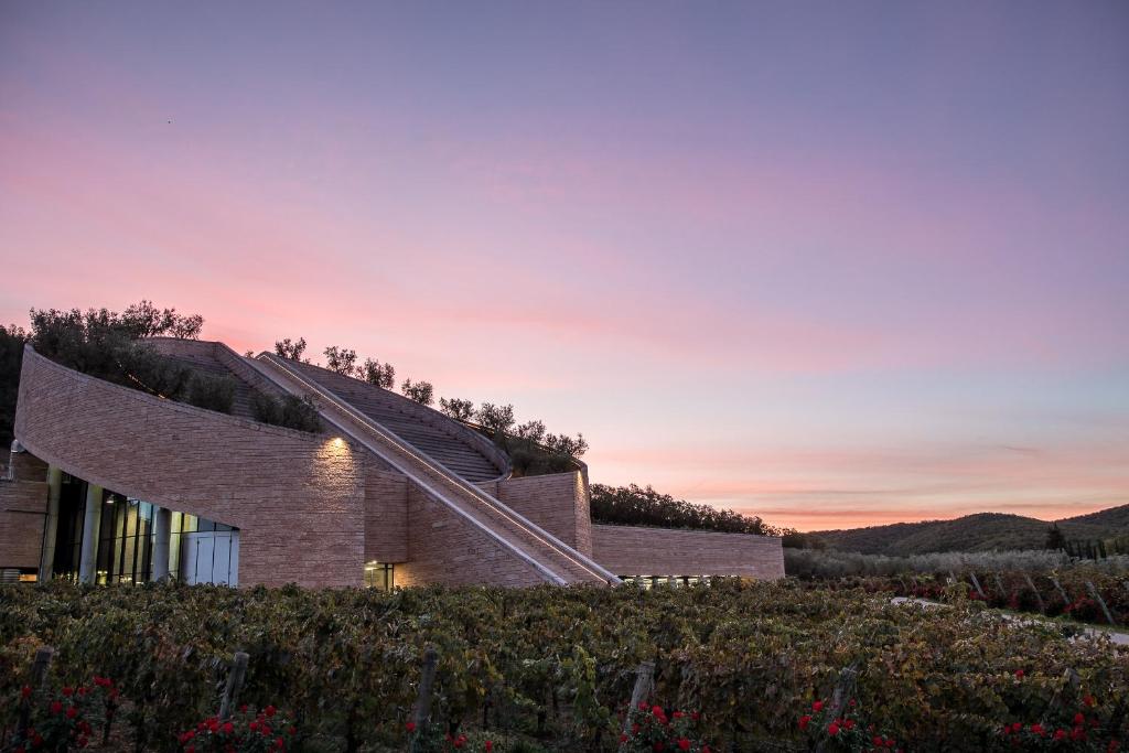 a house on a hill with the sunset in the background at Agriturismo Petra in Suvereto