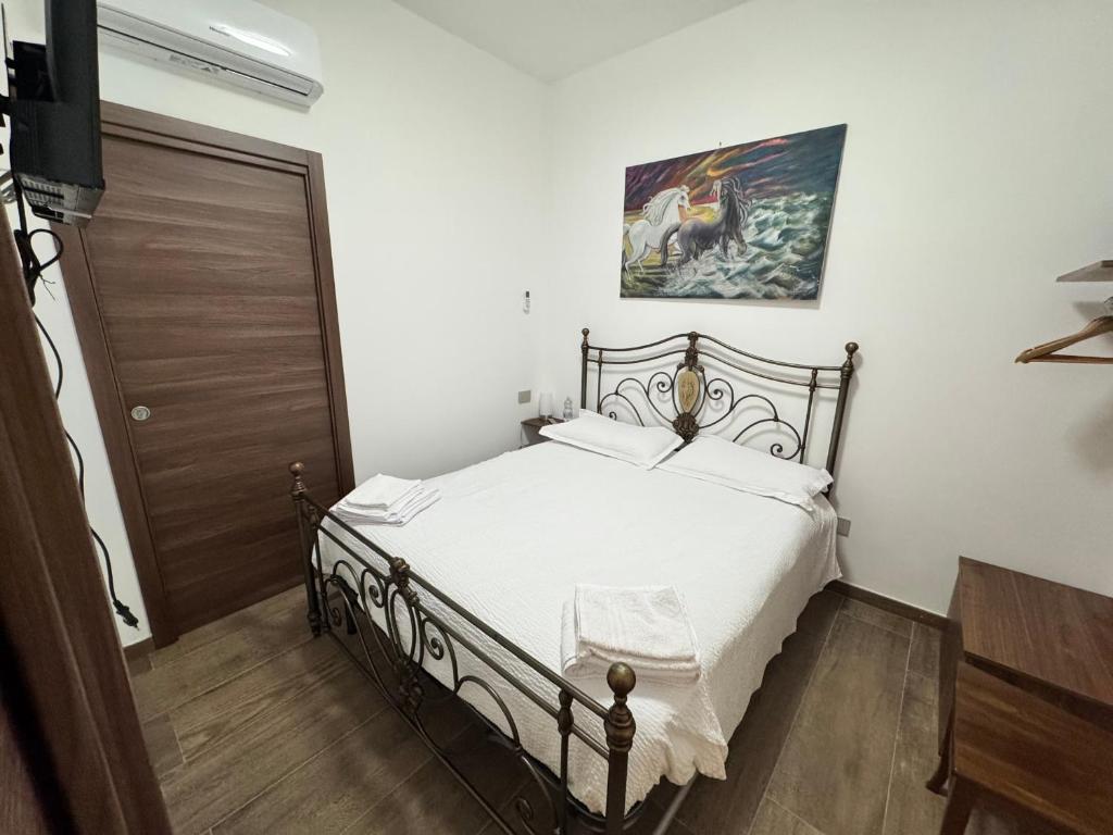 a bedroom with a bed and a painting on the wall at B&B Annunziata- In centro, vicino all' Ospedale di Cosenza in Cosenza