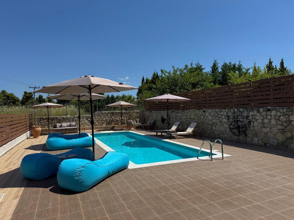 a swimming pool with blue inflatables and an umbrella at Sani Luxury Pool Villa in Sani Beach